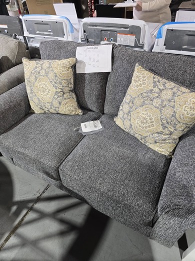 Gray loveseat with floral accent pillows