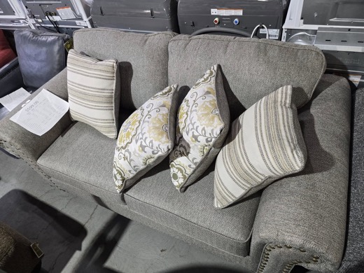 Taupe sofa with nailhead trim and pillows