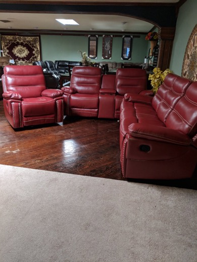 Red leather reclining sofa set in showroom